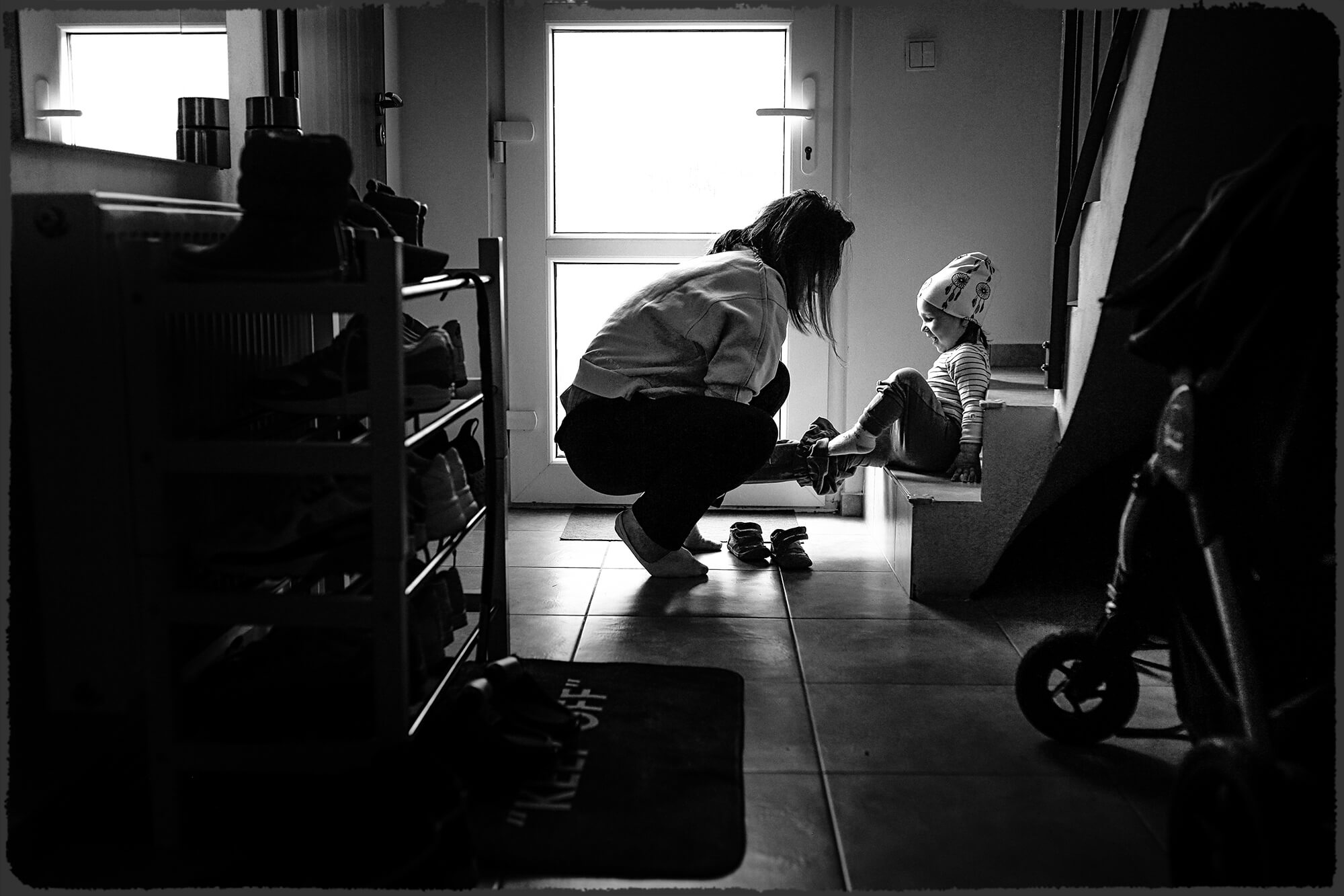Fotografie odrazu v zrcadle, ve kterém jsou vidět svatební šaty, visící na trámu stodoly.