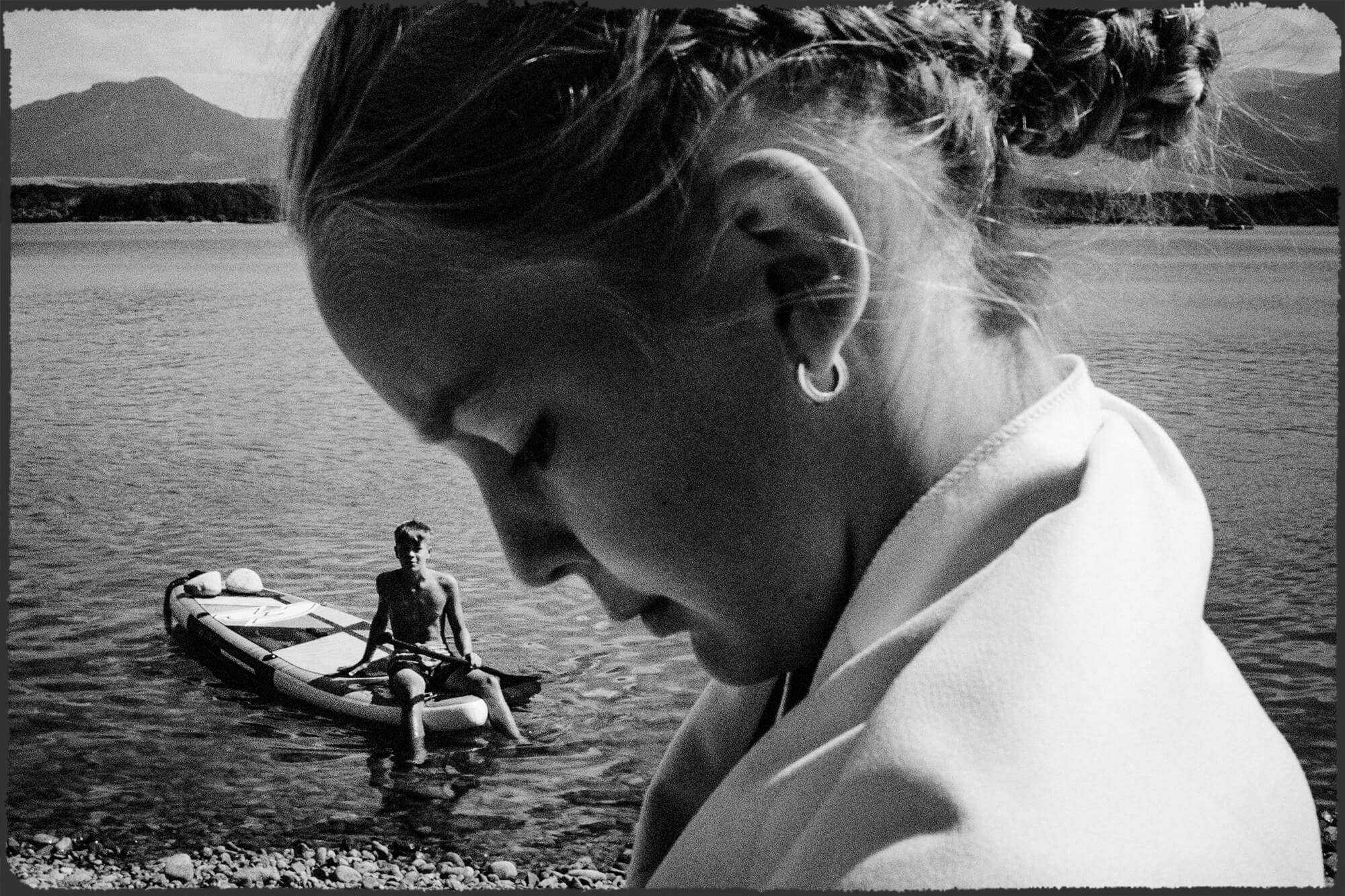 Fotografie odrazu v zrcadle, ve kterém jsou vidět svatební šaty, visící na trámu stodoly.