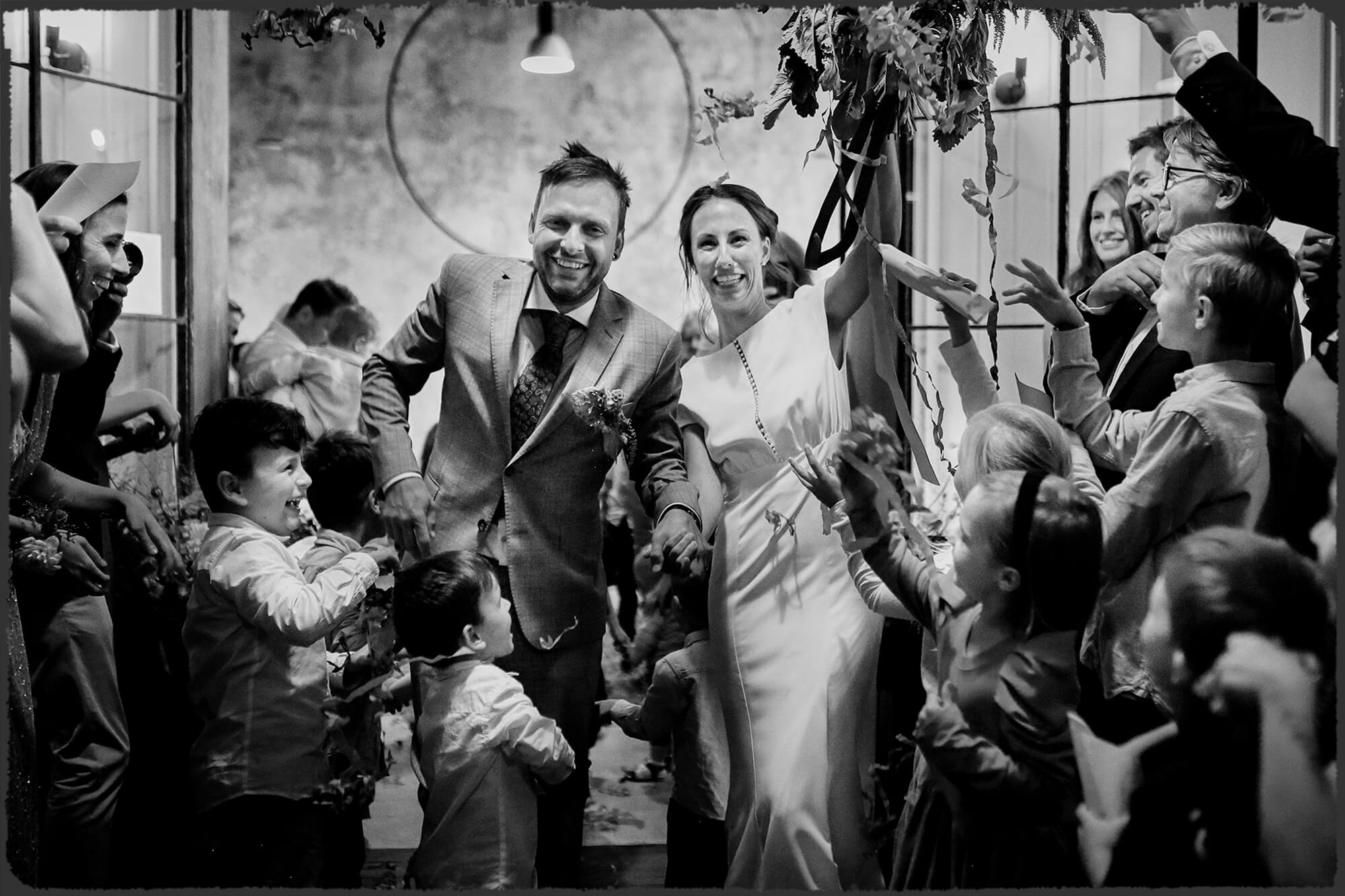 Fotografie odrazu v zrcadle, ve kterém jsou vidět svatební šaty, visící na trámu stodoly.