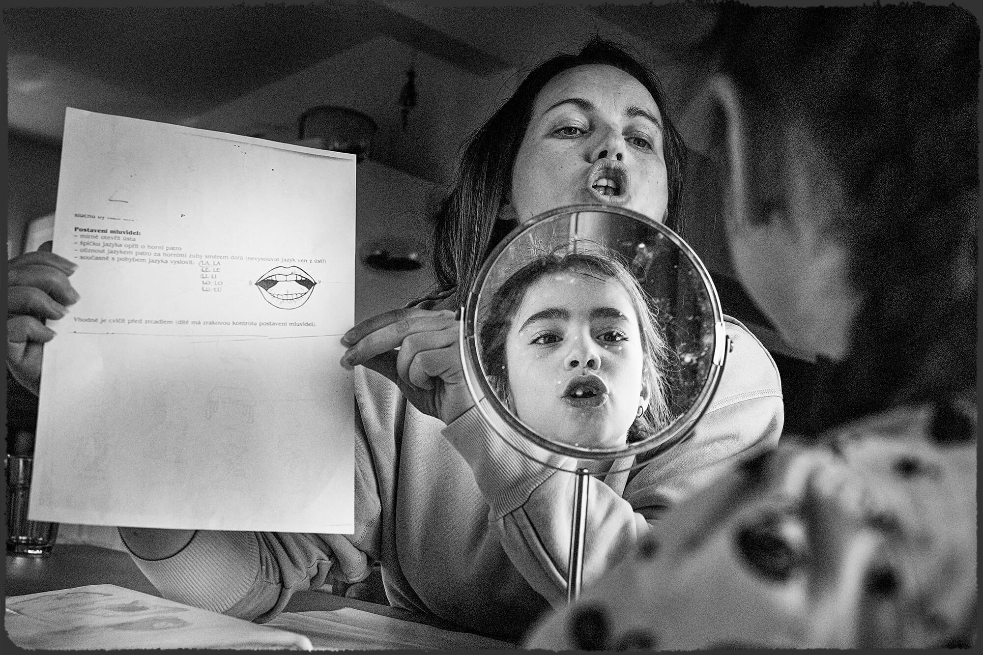Dokumentární rodinná fotografie na které maminka s dcerou procvičují logopedii